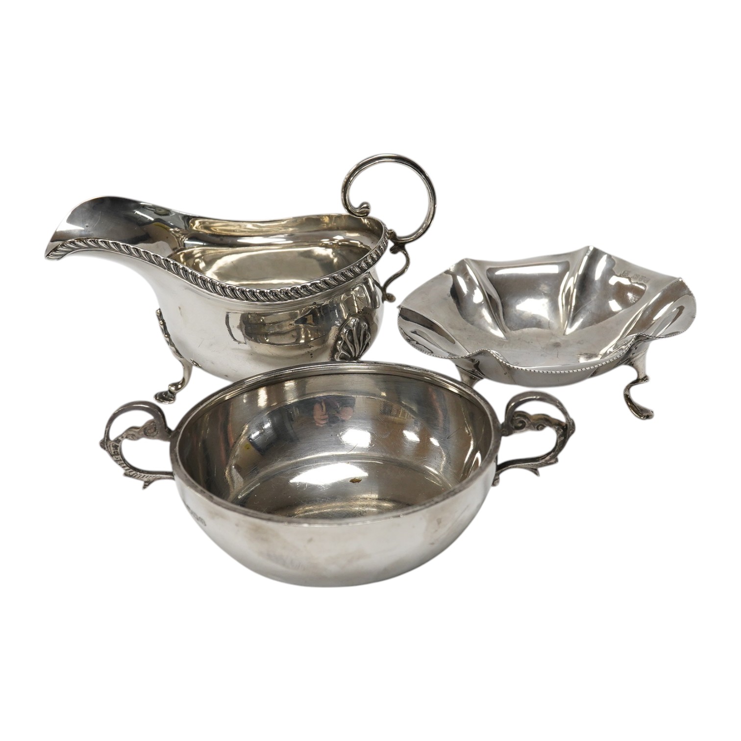 A silver quaich, E J Gallichan & Co Ltd, Sheffield, 1962, diameter 10.2cm, together with a silver sauceboat and a small silver dish, 10.1oz. Condition - fair